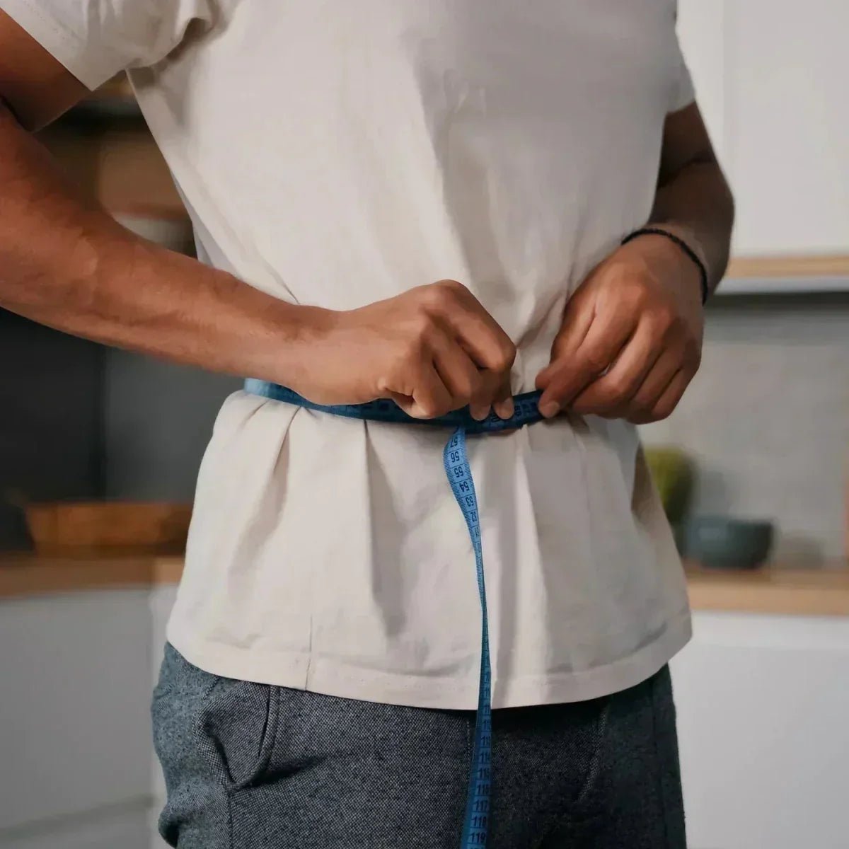 Person misst ihren Bauchumfang