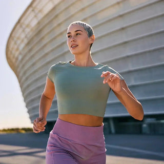 Frau joggt vor Stadion