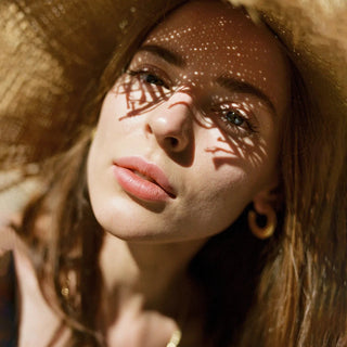 Volto di donna con cappello da sole, al sole.