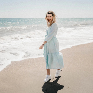 Donna in spiaggia in abito, felice
