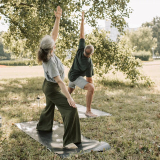 Due persone fanno yoga all’aperto per rilassarsi e sentirsi bene