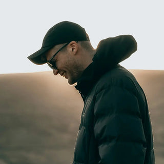 Un uomo con un cappello nero e una giacca nera.