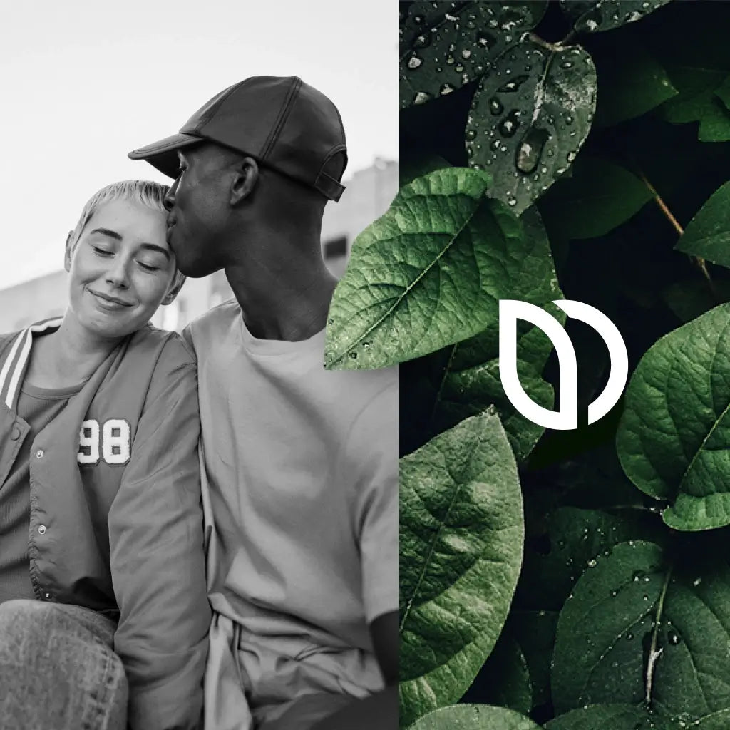 Eine Person küsst eine andere lächelnd auf die Schläfe. Die beiden sitzen nebeneinander. Neben ihnen ist eine Nahaufnahme von grünen Blättern mit Wassertropfen und einer weißen Logo-Überlagerung zu sehen.