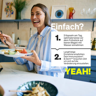 Eine lächelnde Frau in einer Küche hält eine Gabel und einen Teller mit Essen. Der eingeblendete Text in deutscher Sprache gibt Anweisungen zur Einnahme der Kapseln und hebt die Vorteile für das Immunsystem und die Verdauung hervor.