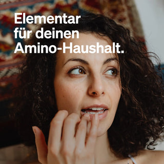 Eine Frau mit lockigem Haar berührt mit ihrer Hand ihre Lippen. Der deutsche Text lautet: "Elementar für deinen Amino-Haushalt", was die Wichtigkeit unterstreicht.