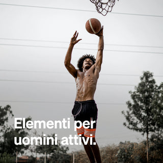 Un uomo in camicia salta per tirare a canestro all'aperto, con alberi e cielo nuvoloso sullo sfondo. Il testo italiano recita: "Elementi per uomini attivi.".