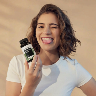 Eine Frau im T-Shirt lächelt und zwinkert, in der Hand hält sie eine Flasche Magnesium Blend", die die Vorteile des natürlichen Elements hervorhebt.