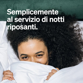 Eine Person mit lockigem Haar liegt im Bett, teilweise mit einer Decke zugedeckt, darüber ein italienischer Text: "Semplicemente al servizio di notti riposanti.