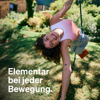 Eine Person hängt kopfüber an einer Schaukel. Der deutsche Text lautet: "Elementar bei jeder Bewegung.