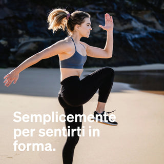 Donna che si allena su una spiaggia sabbiosa, sollevando un ginocchio e un braccio, in abbigliamento sportivo. Testo bianco in italiano recita: "Semplicemente per sentirti in forma."