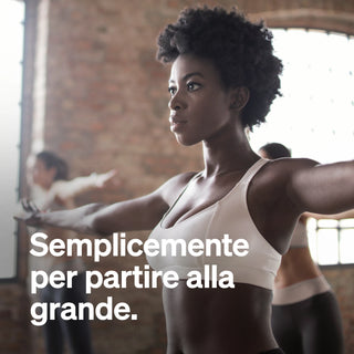 Una donna in abbigliamento sportivo sta con le braccia distese in una palestra; il testo recita: "Semplicemente per partire alla grande."