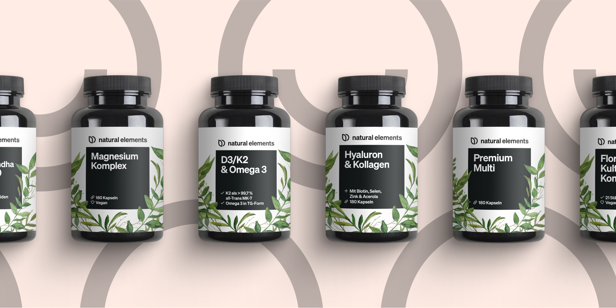 Fünf Flaschen Bittersalz auf rosa Hintergrund, die die natürlichen Elemente zur Geltung bringen.