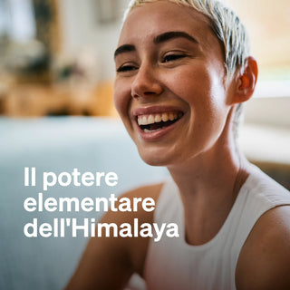 Persona sorridente con capelli corti e chiari, che indossa un top senza maniche. Il testo in italiano recita: "Il potere elementare dell'Himalaya."