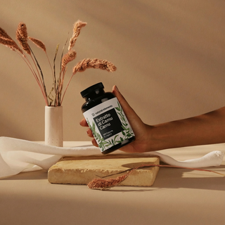 Eine Hand hält eine Flasche mit der Aufschrift "Extrato de Camu Camu".