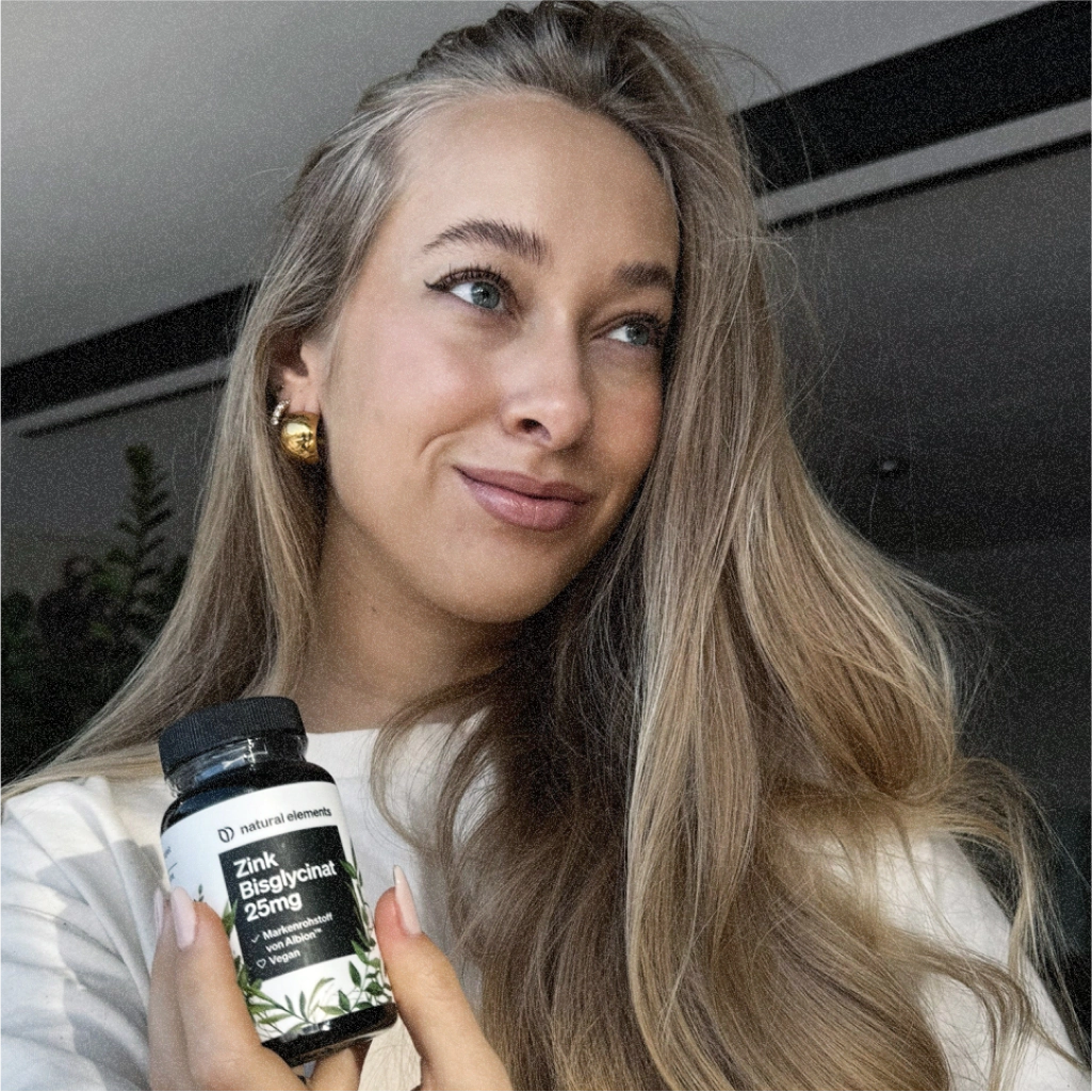 Eine Frau hält eine Flasche Vitamin C hoch, das aus natürlichen Elementen gewonnen wird.